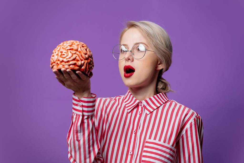 Beautiful woman in red striped shirt hold human brain